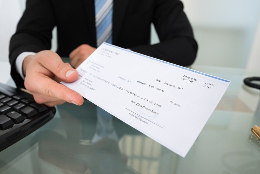 Man handing over a check for ERC refund process 2025.